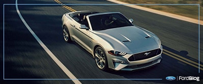 Ford Mustang 2019 convertible gris maneja con potencia y velocidad en carretera