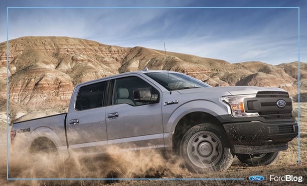 Ford F-150 poder para atravesar caminos de tierra frente a una montaña