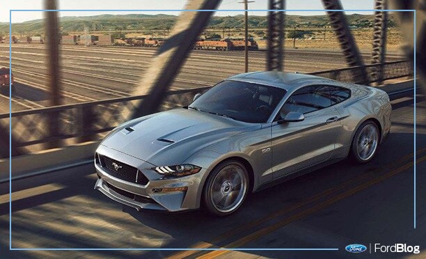 Ford Mustang 2019 gris circula con potencia y velocidad por un puente